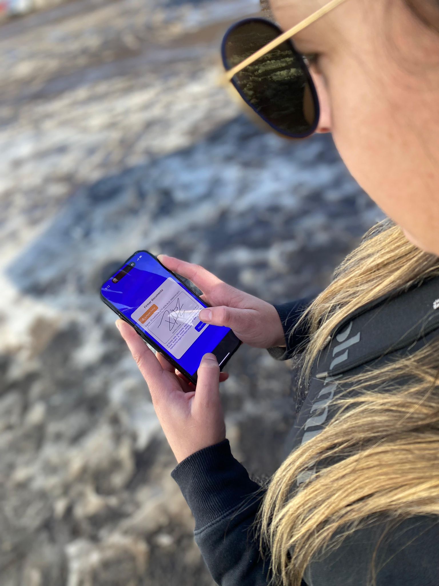 Persona firmando en celular en la montaña